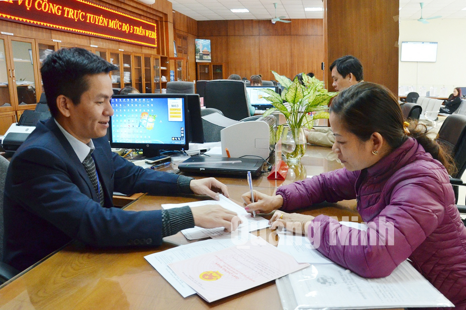 Cán bộ Trung tâm Hành chính công TP Cẩm Phả hướng dẫn công dân hoàn thiện hồ sơ thủ tục hành chính. Ảnh: Nguyễn Thanh