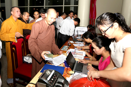 Các doanh nghiệp, tổ chức, cá nhân nộp tiền ủng hộ Dự án đưa điện lưới ra huyện đảo Cô Tô tại bàn đón nhận