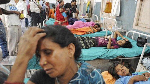 Bà mẹ có con cùng bị ngộ độc sau bữa ăn miễn phí ở trường học (Ảnh: Reuters)