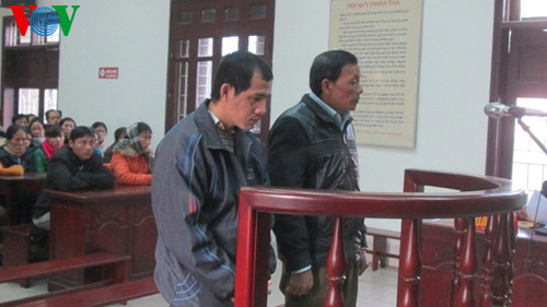 Hai bị cáo Quang và Quy trước vành móng ngựa.