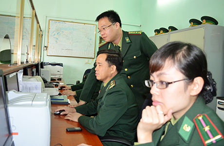 Đại uý Nguyễn Mạnh Linh (đứng) cùng CBCS của đơn vị giải quyết thủ tục xuất nhập cảnh cho du khách.
