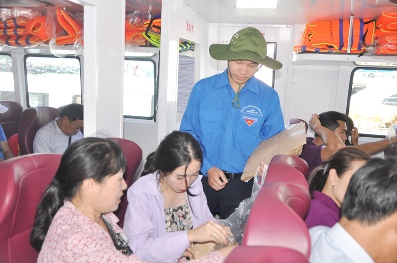 Đoàn viên thanh niên huyện Cô Tô phát túi giấy, tuyên truyền cho du khách ra Cô Tô không mang túi nilon lên đảo để bảo vệ môi trường.