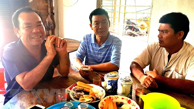 Ông Trương Văn Chóng (bên trái) đoàn tụ cùng người thân. (Ảnh: Thanh Liêm/TTXVN)
