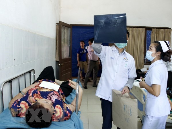 Các bác sỹ Lào chăm sóc cho các nạn nhân trong vụ tai nạn. (Ảnh: Phạm Kiên/TTXVN)
