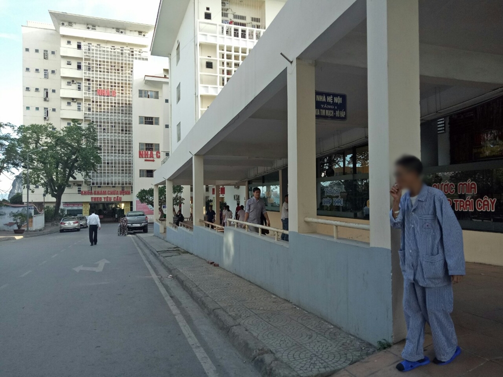 Hút thuốc lá ở nơi công cộng vẫn diễn ra phổ biến. Trong ảnh: Một bệnh nhân tranh thủ hút thuốc trong lúc chờ khám bệnh