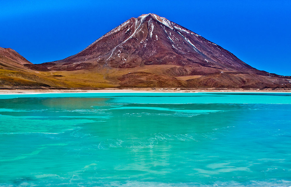 Laguna Verde, Bolivia: Cũng giống như Laguna Colorada, Laguna Verde là kỳ quan độc đáo của Bolivia. Nằm ở chân núi lửa Licancabur đã ngừng hoạt động, hồ muối này có màu xanh lá cây rực rỡ do các mỏ khoáng sản tạo nên. Điều thú vị nhất là điều kiện khí hậu không ảnh hưởng trạng thái nước trong hồ. Trong mùa đông, dù nhiệt độ giảm xuống mức -56 độ C, nước trong hồ vẫn luôn ở trạng thái lỏng. Ảnh: Worldface.