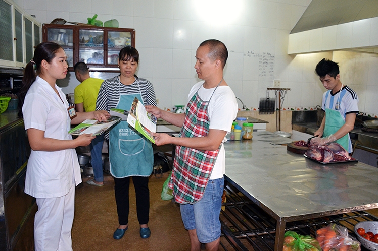 Cán bộ y tế huyện Hoành Bồ phát tờ rơi tuyên truyền về đảm bảo VSATTP tại các cơ sở dịch vụ ăn uống trên địa bàn.