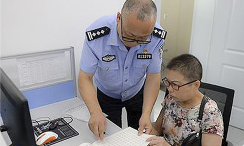 Trong khi bận làm việc, cảnh sát Wu Feng dỗ vợ luyện viết chữ để giết thời gian. Ảnh: SCMP.