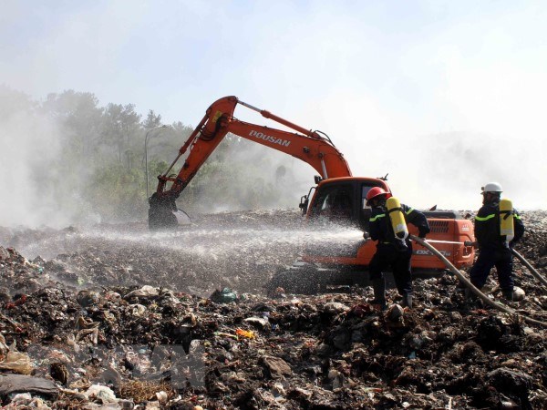 Dập lửa tại bãi rác. (Ảnh: Tá Chuyên/TTXVN)