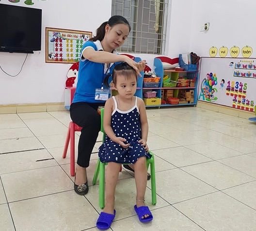 Cô giáo chăm sóc các em học sinh 