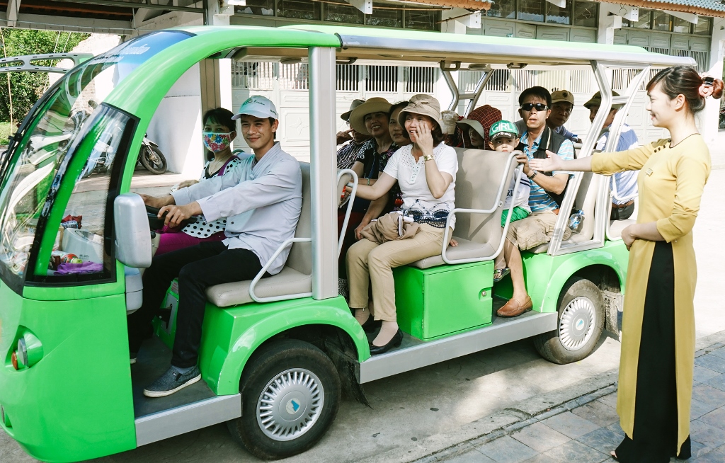 Nhân viên Công ty CP Phát triển Tùng Lâm hướng dẫn du khách lên xe điện. Ảnh: Phòng VH-TT Uông Bí