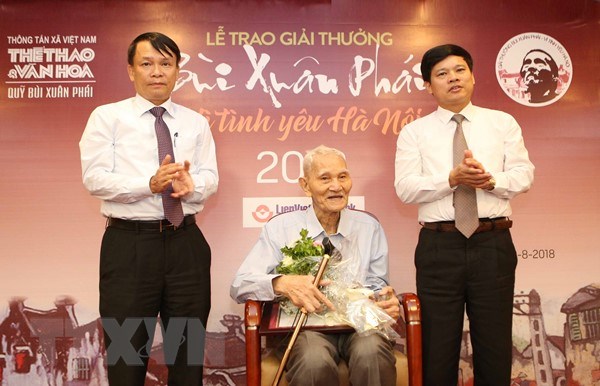 Tổng giám đốc Thông tấn xã Việt Nam (ngoài cùng bên trái) và Phó Chủ tịch Ủy ban Nhân dân thành phố Hà Nội Ngô Văn Quý trao Giải thưởng Lớn - Vì tình yêu Hà Nội cho ông Nguyễn Bá Đạm. (Ảnh: TTXVN)