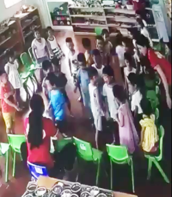Bé trai đứng khóc nức nở sau khi bị cả chục bạn trong lớp đánh hội đồng. Ảnh cắt từ clip.