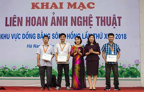 Nguyễn Hải Huy (thứ hai, trái sang) nhận huy chương bạc Liên hoan ảnh nghệ thuật 9 tỉnh Đồng bằng Sông Hồng 2018.