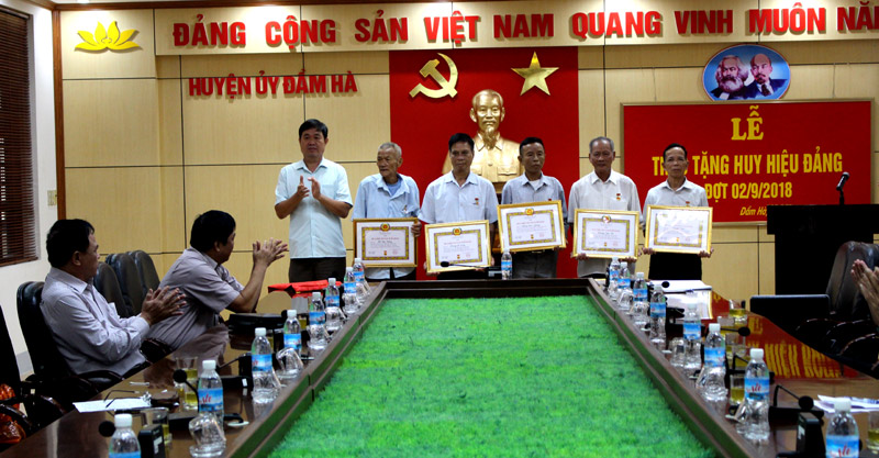 Đồng chí Vũ Văn Phú, Phó Bí thư Thường trực Huyện ủy trao Huy hiệu Đảng cho các đảng viên.
