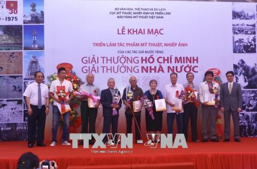 Phó thủ tướng Vũ Đức Đam và Thứ trưởng Bộ Văn hoá Thể thao và Du Lịch Lê Khánh Hải tặng sách và hoa cho các tác giả và đại diện gia đình cố tác giả có tác phẩm triển lãm. Ảnh: Minh Quyết/TTXVN