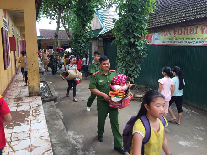 Cán bộ, chiến sĩ công an, quân đội tham gia giúp trường Phổ thông DTNT THCS Con Cuông di dời đồ đạc. Ảnh Bá Hậu.