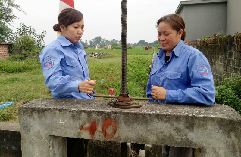 Chị Đàm Thị Huyền cùng đồng nghiệp đang vận hành công đầu nối kênh cấp 2 tại khu vực phường Yên Hải (TX Quảng Yên)