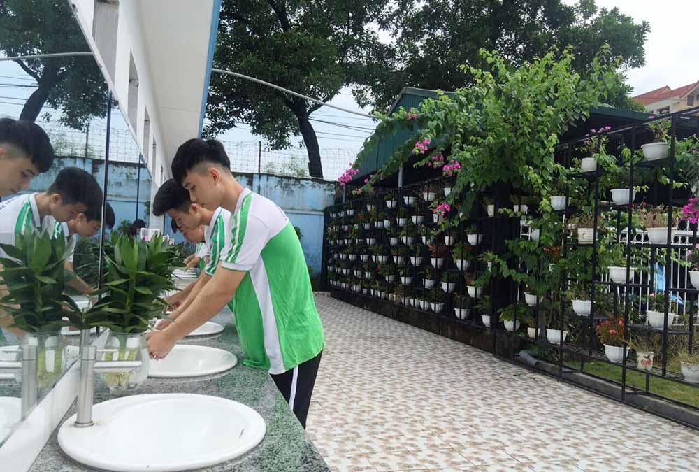 Học sinh Trường THPT Hoàng Quốc Việt rửa tay tại khu vực nhà vệ sinh mới được sửa chữa.