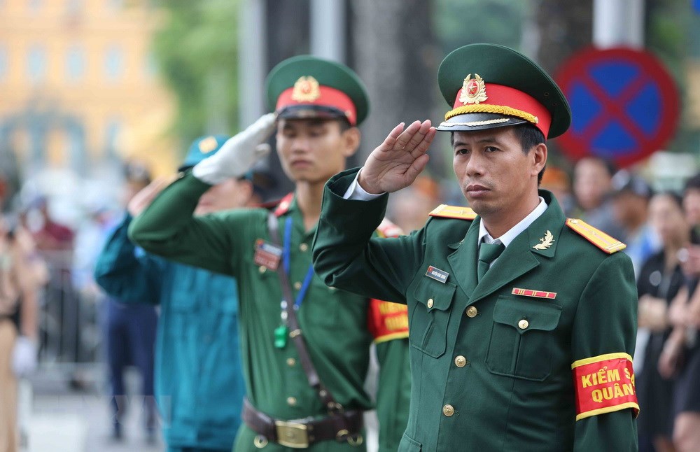 Cán bộ, chiến sỹ lực lượng vũ trang thực hiện nghi thức khi xe đưa linh cữu Chủ tịch nước Trần Đại Quang đi qua. (Ảnh: TTXVN)