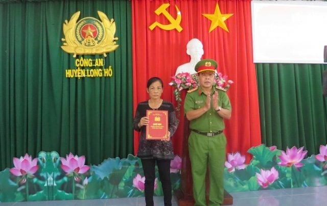 Đại tá Trần Văn Thắng, Trưởng Công an huyện Long Hồ trao quyết định thăng bậc hàm cho thân nhân Trung úy Nguyễn Đức Đạt.