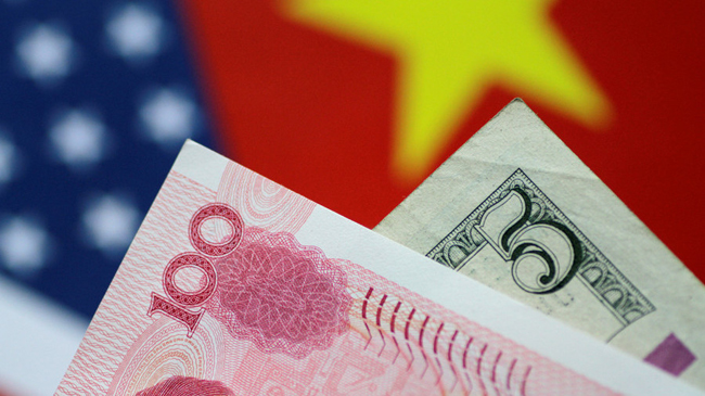 Đồng nhân dân tệ và USD. Ảnh: Reuters