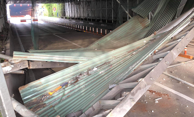 Khung mái che bị xe tải kéo đổ sập xuống đường.