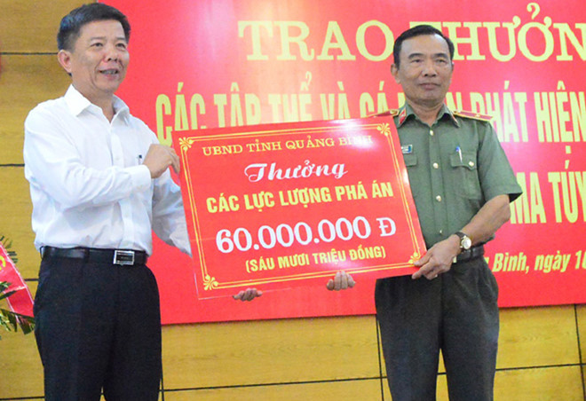 Chủ tịch UBND tỉnh Quảng Bình trao phần thưởng nóng cho các cá nhân, tập thể. Ảnh: Văn Được.