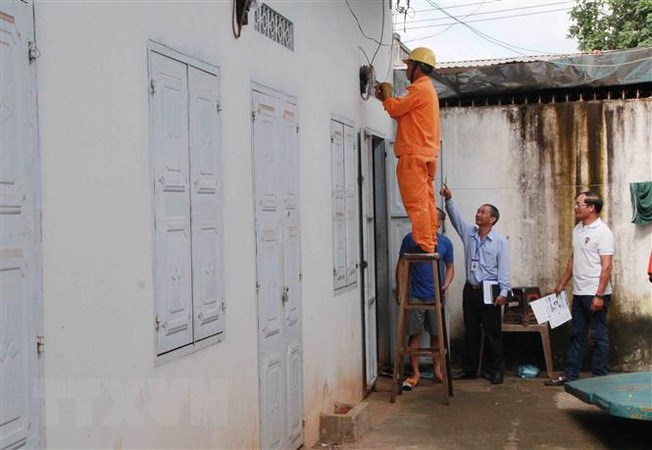 Công nhân Điện lực kiểm tra côngtơ điện tại một nhà trọ. (Ảnh: Phạm Cường/TTXVN)