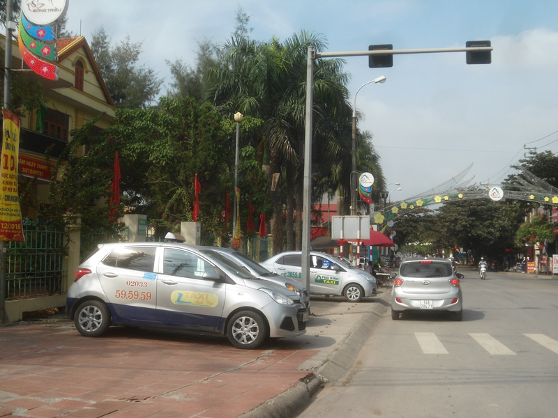 Phần lớn diện tích vỉa hè trên QL18 đoạn từ cổng Phòng TN-MT TX Đông Triều đến cổng sân vận động đã bị chiếm dụng thành điểm dừng đỗ taxi. (Ảnh chụp hồi 10 giờ 30 ngày 17/12/2018).