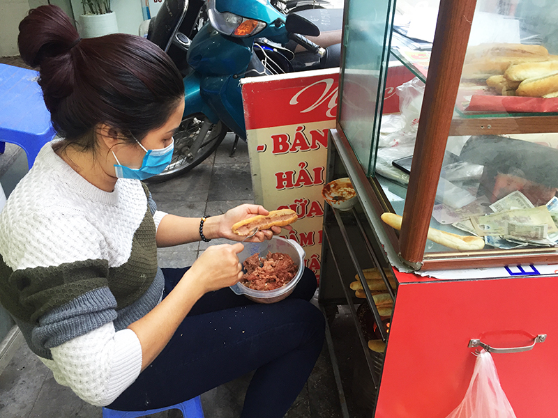 Một quầy bán thức ăn đường phố trên đường Lê Thánh Tông, TP Hạ Long sử dụng tay tiếp xúc trực tiếp với thức ăn ngay.