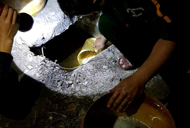 Công nhân đang vớt dầu từ kênh mương dân sinh nhằm hạn chế mức độ ảnh hưởng. Ảnh: Quỳnh An.