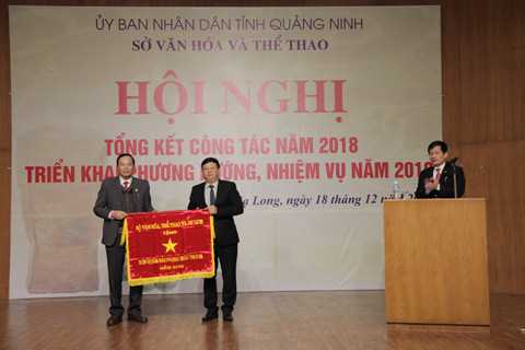 Đồng chí Phùng Huy Cẩn, Vụ trưởng Vụ thi đua khen thương của Bộ VHTT&DL (bên phải) trao cờ đơn vị dẫn đầu phong trào thi đua cho phòng Văn hóa Thông tin huyện Hoành Bồ