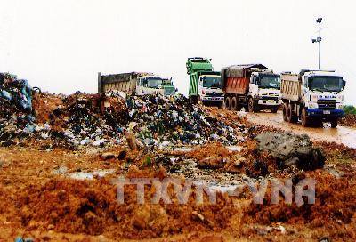 Chôn lấp rác thải ở bãi rác Nam Sơn. Ảnh: Bùi Tường/TTXVN