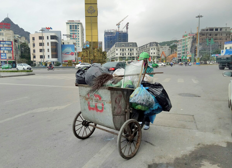 Công nhân Công ty CP Đầu tư và Phát triển môi trường đô thị Quảng Ninh thu gom rác thải sinh hoạt ở tuyến đường Lê Thánh Tông, TP Hạ Long.
