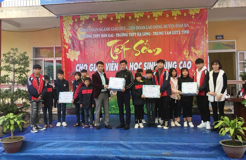 Đại diện Trường THPT Hòn Gai tặng quà cho học sinh có hoàn cảnh khó khăn tại xã Quảng Lâm.