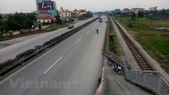 Lối lên xuống cầu vượt lại dẫn người đi bộ xuống thẳng lòng Quốc lộ 5 một cách rất... bất hợp lý (Ảnh: PV/Vietnam+)