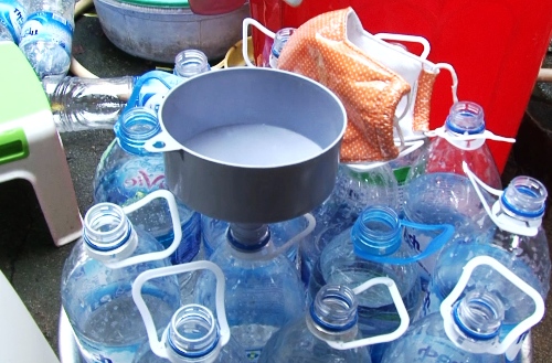 Những chai nước khoáng đã qua sử dụng được bà Mùa mua lại để đựng giấm pha bằng axit. Ảnh: Văn Nam.