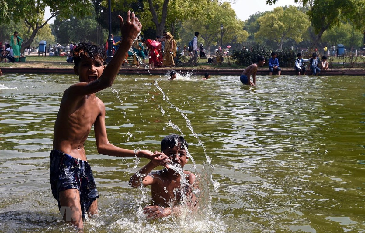 Trẻ em giải nhiệt tránh nóng tại một ao nước ở New Delhi của Ấn Độ ngày 7/6. (Ảnh: THX/TTXVN)
