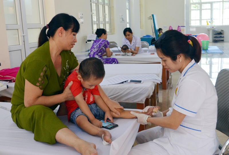 Bác sĩ đang kiểm tra điều trị cho cháu Phạm Hải Đăng (phường Mông Dương) bị tai nạn do tàu hỏa kẹp ở chân.