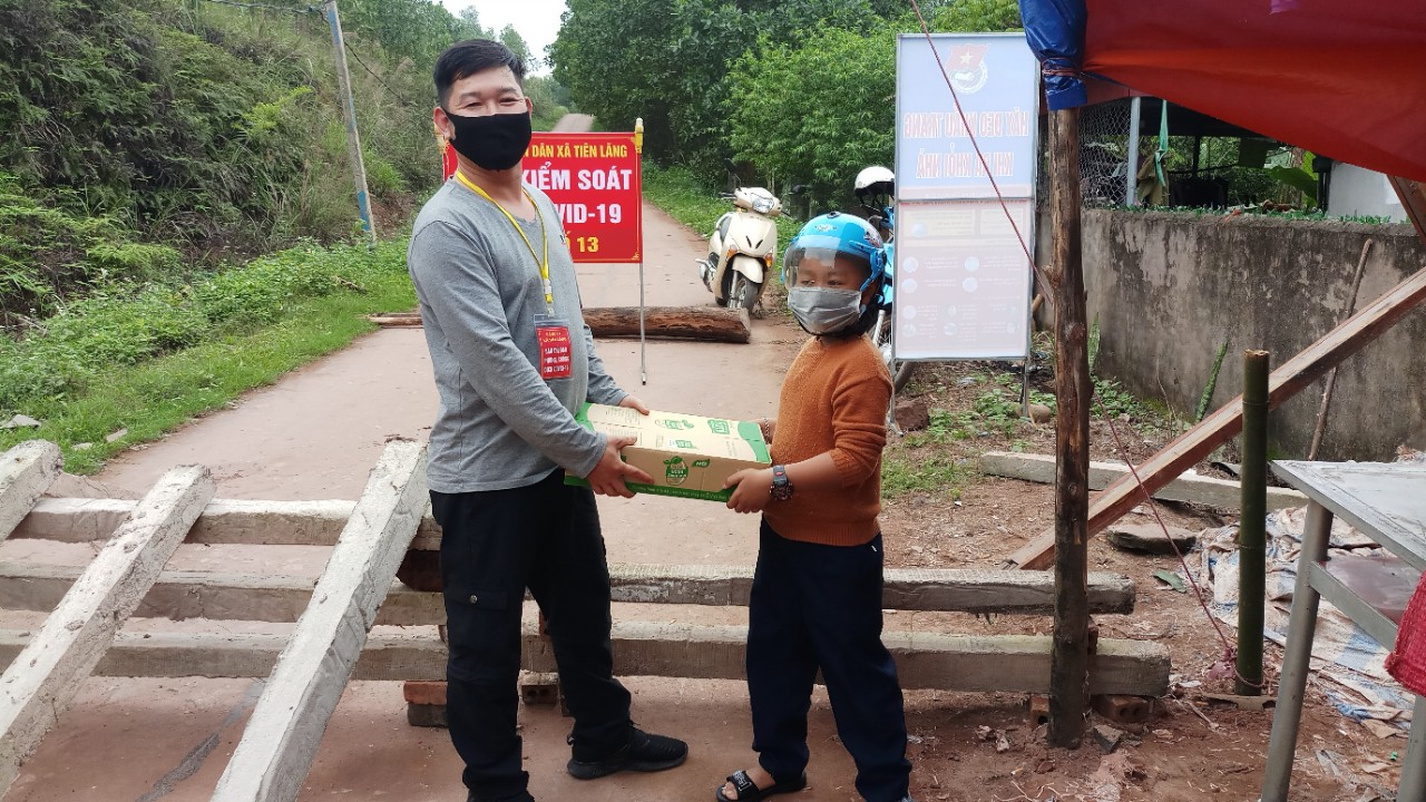 Bé Tô Minh Quân trực tiếp trao tận tay các vỉ sữa cho lực lượng làm nhiệm vụ kiểm soát dịch trên địa bàn xã Tiên Lãng.