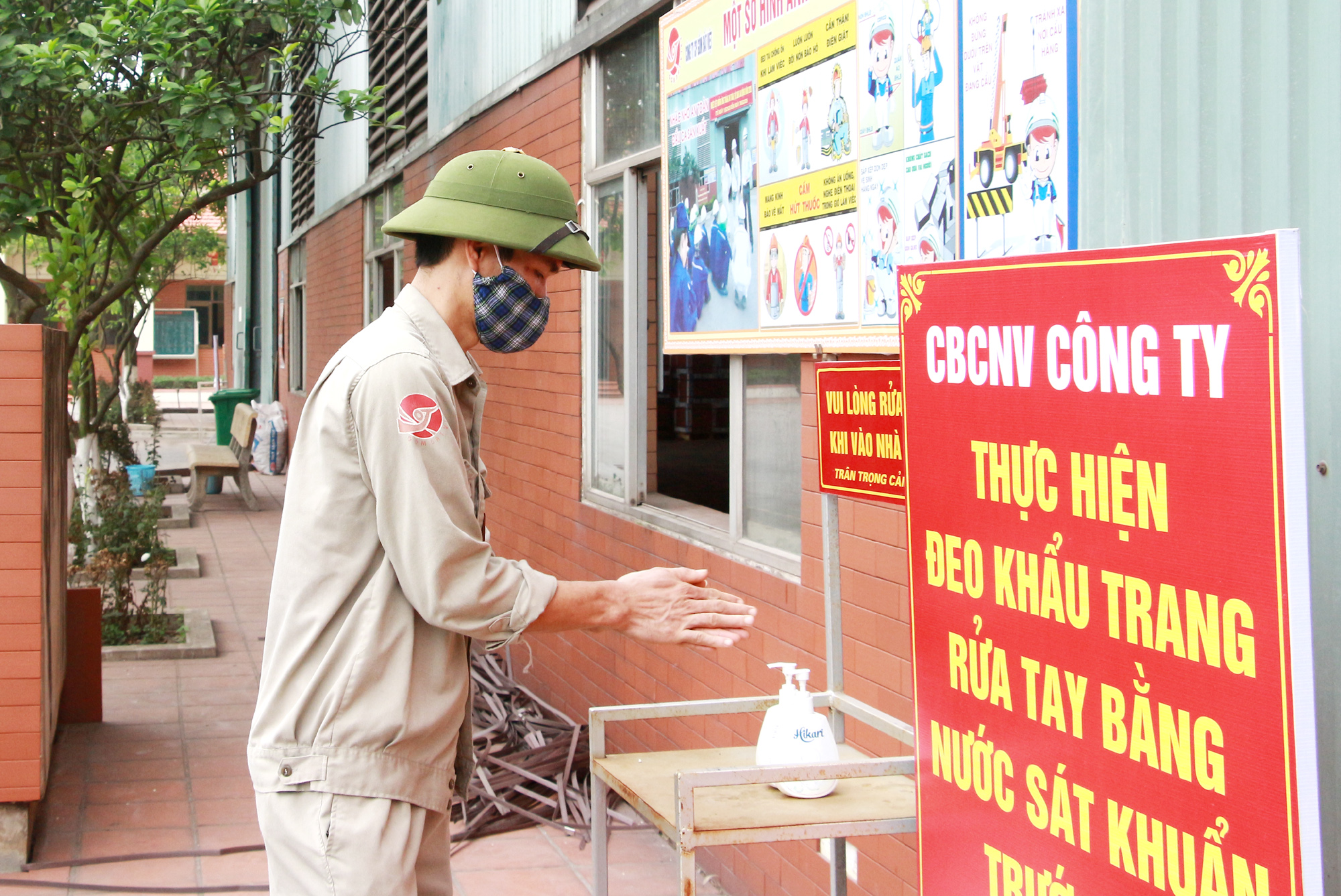 Thực hiện sát khuẩn tay trước khi vào nhà máy tại Công ty CP Gốm Đất Việt. Ảnh: Mạnh Trường