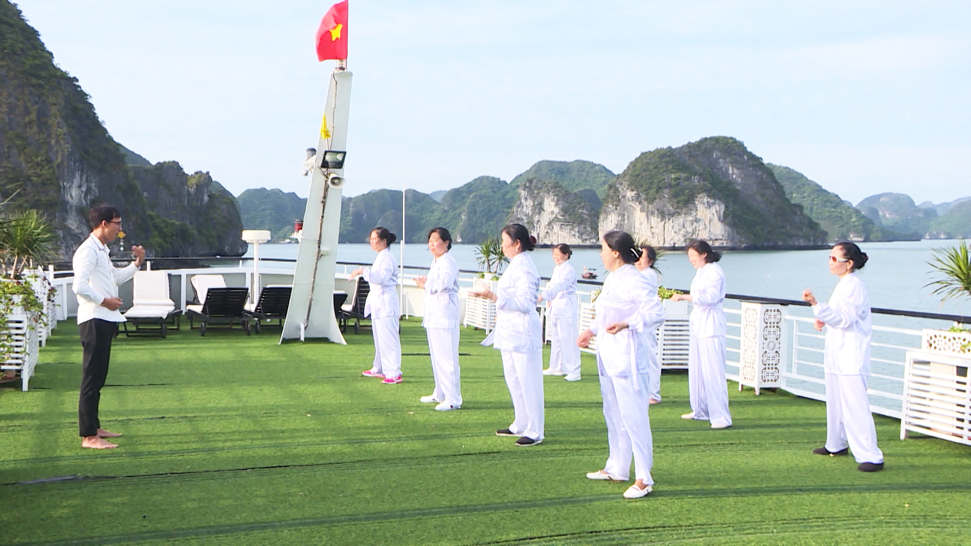 Khách du lịch tập thể dục sáng khi sử dụng dịch vụ tàu nghỉ đêm trên vịnh.