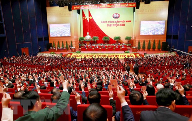 Các đại biểu biểu quyết, thông qua Nghị quyết Đại hội XIII Đảng Cộng sản Việt Nam. (Ảnh: TTXVN)