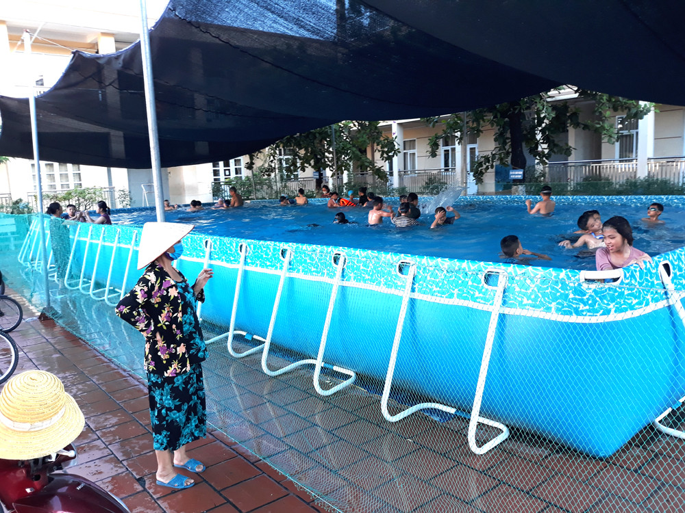 Trong những ngày nóng bức các bê bơi di động được nhiều gia đình đưa con em mình đến (Bể bơi di động tại sân Trường Tiểu học Cẩm Bình (TP Cẩm Phả)