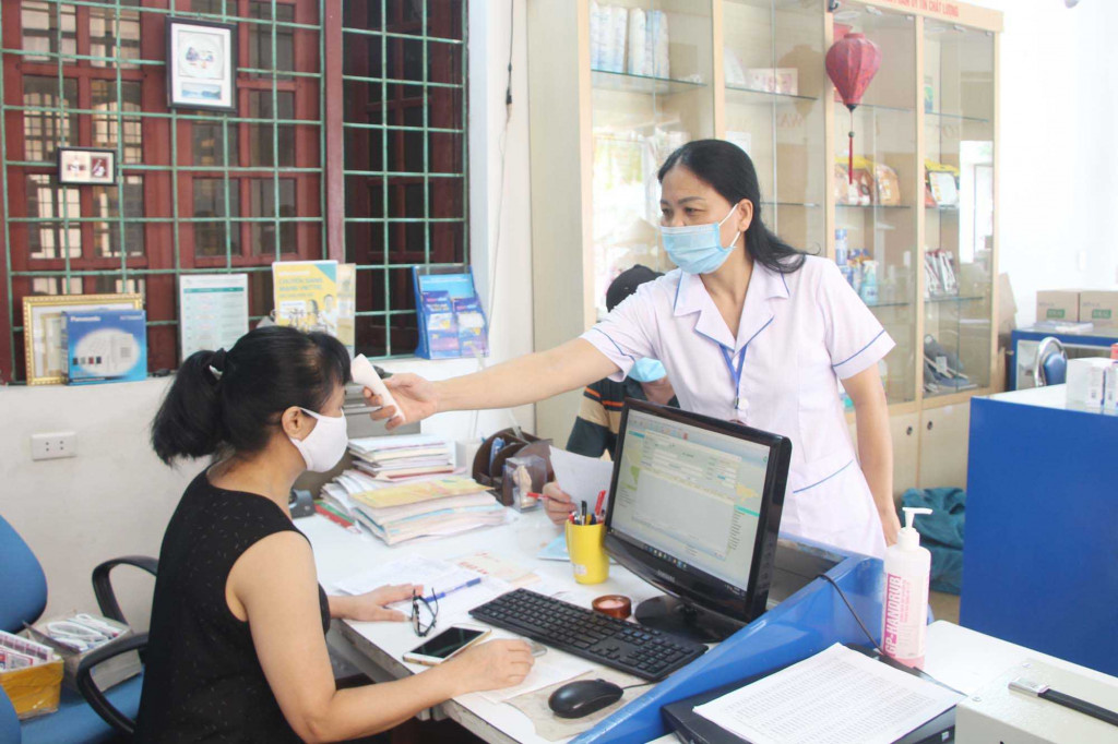 Nhân viên Trạm Y tế phường Hoành Bồ (TP Hạ Long) kiểm tra thân nhiệt cho người dân trên địa bàn.