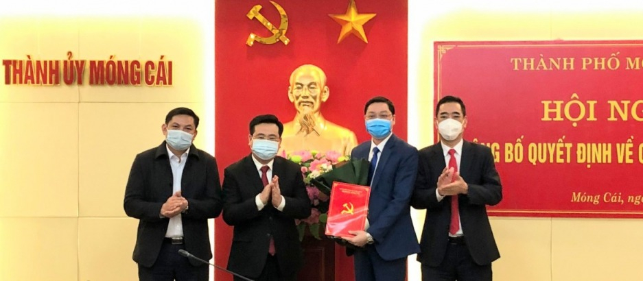 Bí thư Thành ủy Móng Cái, Hoàng Bá Nam, trao Quyết định cho đồng chí Hoàng Ngọc Anh, Chánh Văn phòng Thành ủy.