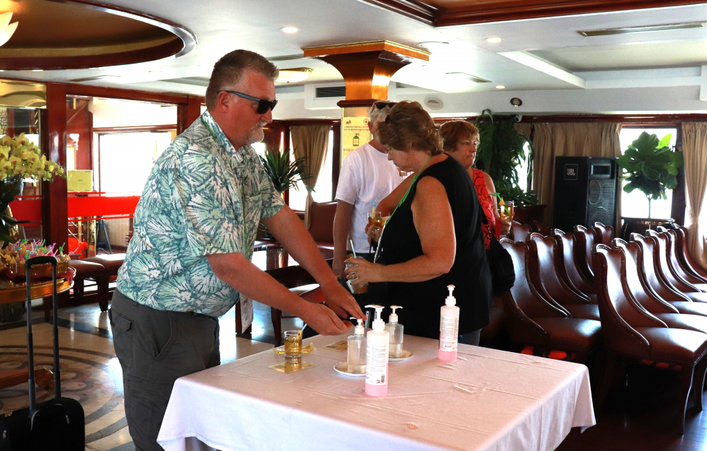 Du khách Mỹ rửa tay sát khuẩn trên tàu nghỉ đêm tham quan Vịnh Hạ Long.