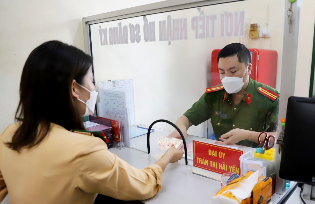 Đại úy Trần Thị Hải Yến, cán bộ Đội CAGT-TT (Công an TX Quảng Yên) giao đăng ký xe máy cho Công an phường Phong Hải.