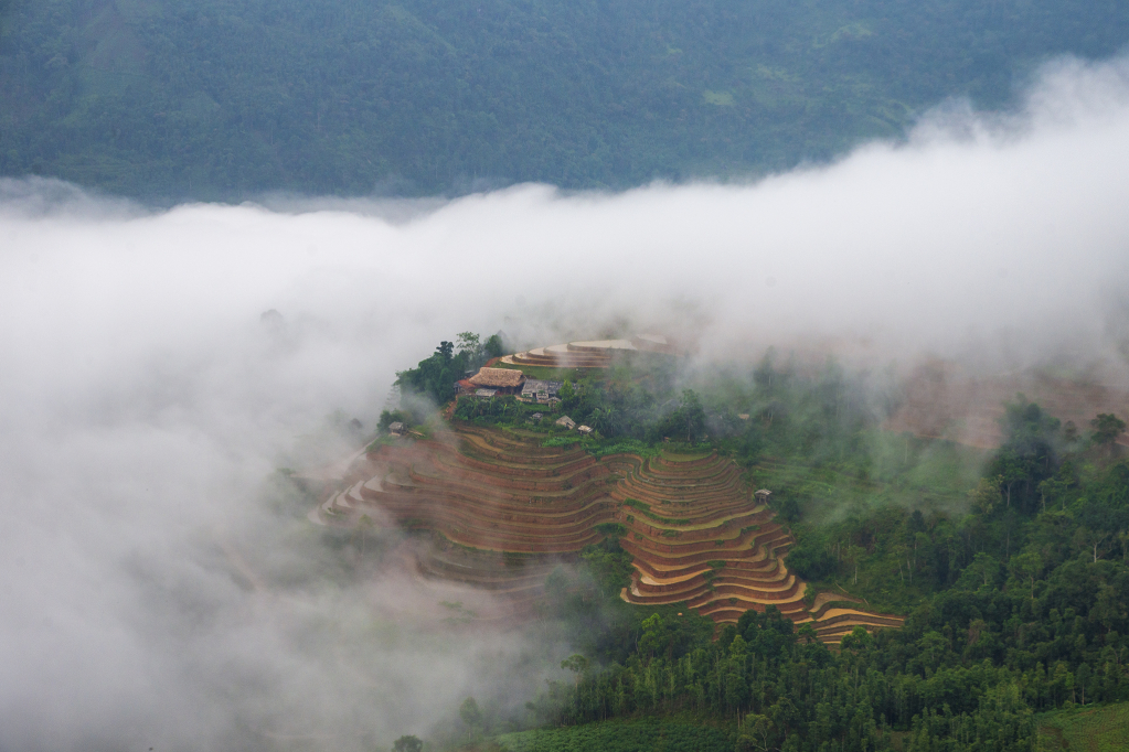 Mây trùm lên những ngôi nhà và thửa ruộng.